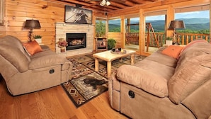 A cozy cabin interior with two sofas, a fireplace, and a balcony with a scenic view. - Mountain Splendor: Best Mountain View in Starr Crest Resort - Brand New Hot Tub (Sevierville)