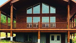 A large wooden building with a balcony, multiple windows, and a door.