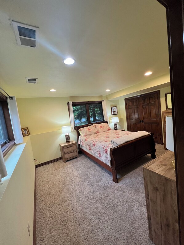 A bedroom with a bed, nightstands, a window, and a door. - Pristine condo! Walking distance to everything in the heart of Fish Creek! (Fish Creek)