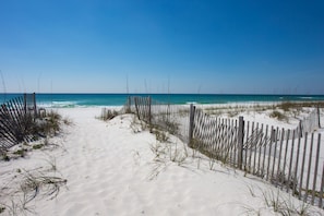 A sandy beach path with wooden fences and sparse vegetation. - Stone Crab Cottage: Directly Across from Gulf (Pensacola Beach)