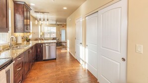 A spacious kitchen with wooden cabinets, a stainless steel dishwasher, and a granite countertop. - Townhome 4 in Springdale, at Zion National Park (Springdale)