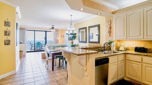 A spacious kitchen with a large island, a dining area with a view, and a ceiling fan.