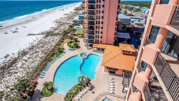 A resort with a large pool, beach access, and high-rise buildings.