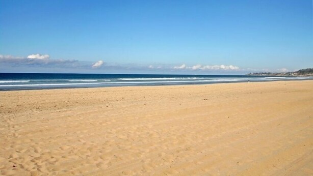 A wide sandy beach with gentle waves and a clear blue sky. - Charming  2 Bedroom/2 Bath with Fireplace, Beach is 2 min Walk (San Diego)