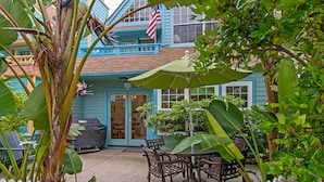 A blue house with a white picket fence, a patio with a table and chairs, and a covered grill. - Charming  2 Bedroom/2 Bath with Fireplace, Beach is 2 min Walk (San Diego)