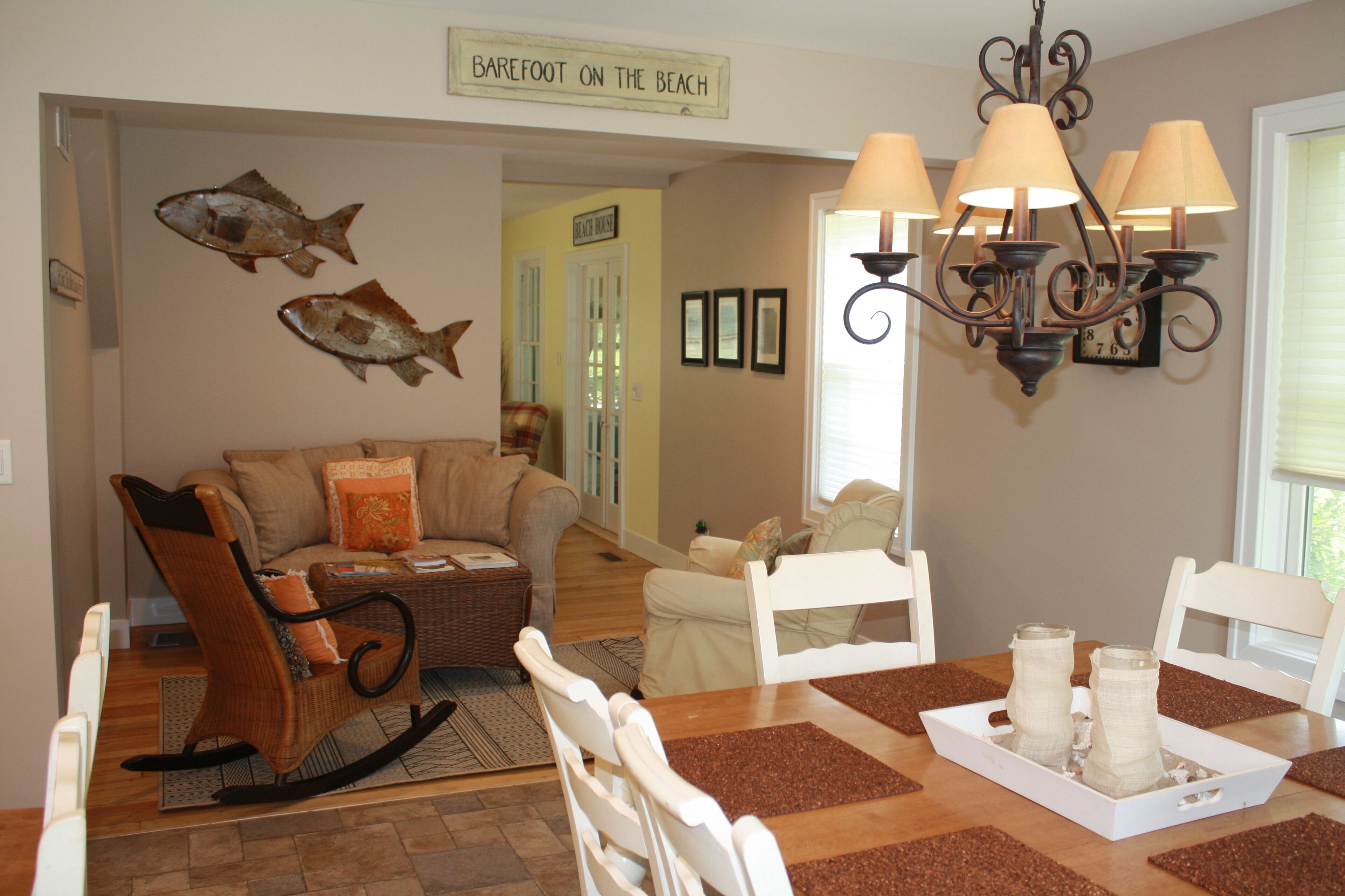 A dining area with a wooden table, white chairs, and a chandelier.