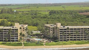 Ein Resort mit mehreren Gebäuden, einem Strand und Blick auf die umliegende Landschaft.