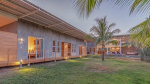A modern building with a covered walkway and a pool area. - Spacious Modern Home w/pool in gated community (Playa Guiones)