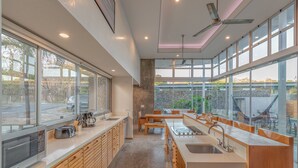 A modern kitchen with large windows, a dining area, and a view of the outside. - Spacious Modern Home w/pool in gated community (Playa Guiones)