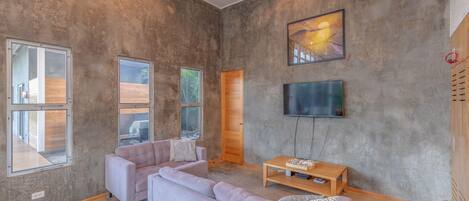 Ein modernes Wohnzimmer mit einer großen Eckcouch, einem Couchtisch und einem flachbildfernseher an der Wand.