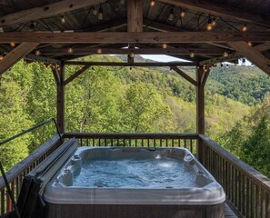 A hot tub on a wooden deck with a view of a forested hillside. - Heavenly Views~Hot Tub+Fire Pit+Fireplace & WiFi! (Spruce Pine)