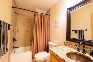 A bathroom with a bathtub, toilet, shower curtain, sink, and a mirror. - Heavenly Views~Hot Tub+Fire Pit+Fireplace & WiFi! (Spruce Pine)