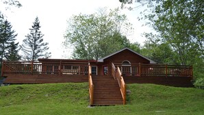 Eine Holzhütte mit Veranda und einer Treppe zum Eingang.