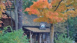 A rustic cabin with a porch and a sign that reads "Rustic."