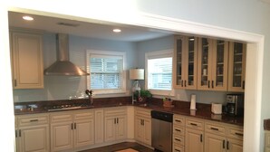 A kitchen with white cabinets, a granite countertop, a stove, and a dishwasher.