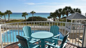 A poolside area with a view of the ocean, surrounded by palm trees and a gazebo. - JUST RENOVATED! Amazing Views!!! Beautiful Updated 2 Bedroom, 2 Bath condo! (Miramar Beach)