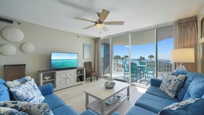 A living room with a TV, sofa, and a view of the ocean. - JUST RENOVATED! Amazing Views!!! Beautiful Updated 2 Bedroom, 2 Bath condo! (Miramar Beach)