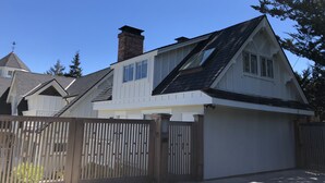 A two-story house with a gabled roof, a chimney, and a fenced yard. - DETACHED GUEST HOUSE: Walk To Town, 1030 Sq Ft, 1 BR/1.5 BA, Mt. Tam Vie (Mill Valley)