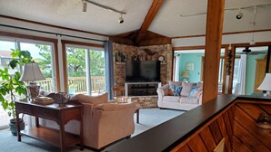 A cozy living room with a fireplace, comfortable seating, and a television. - "He Crab She Crab"  Waterfront Home w/Beach, Bay&Backyard Fun. Perfect for Kids! (Virginia Beach)