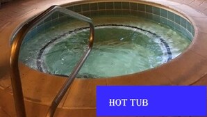 A hot tub in a stone-walled room with large windows. - Perfect in every Way: Nothing to do but relax (Kure Beach)