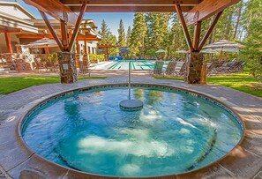 A hot tub with a stone surround, wooden pergola overhead, and a pool table in the background. - Northstar Ski Trails, Ski In/Ski Out - Walk to Village/Rec Center - Sleeps 4 (Truckee)