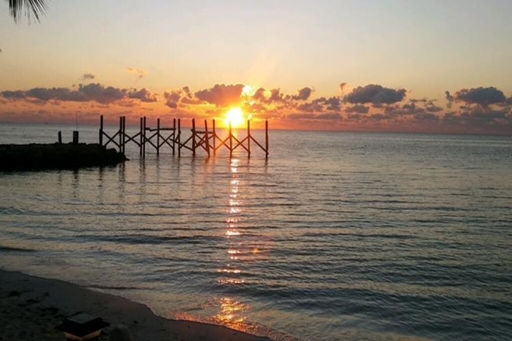 A pier extending into calm waters at sunset.