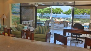 Ein Zimmer mit Meerblick, einem Essbereich mit Tisch und Stühlen sowie einer Sitzecke mit Sofa und Sesseln.