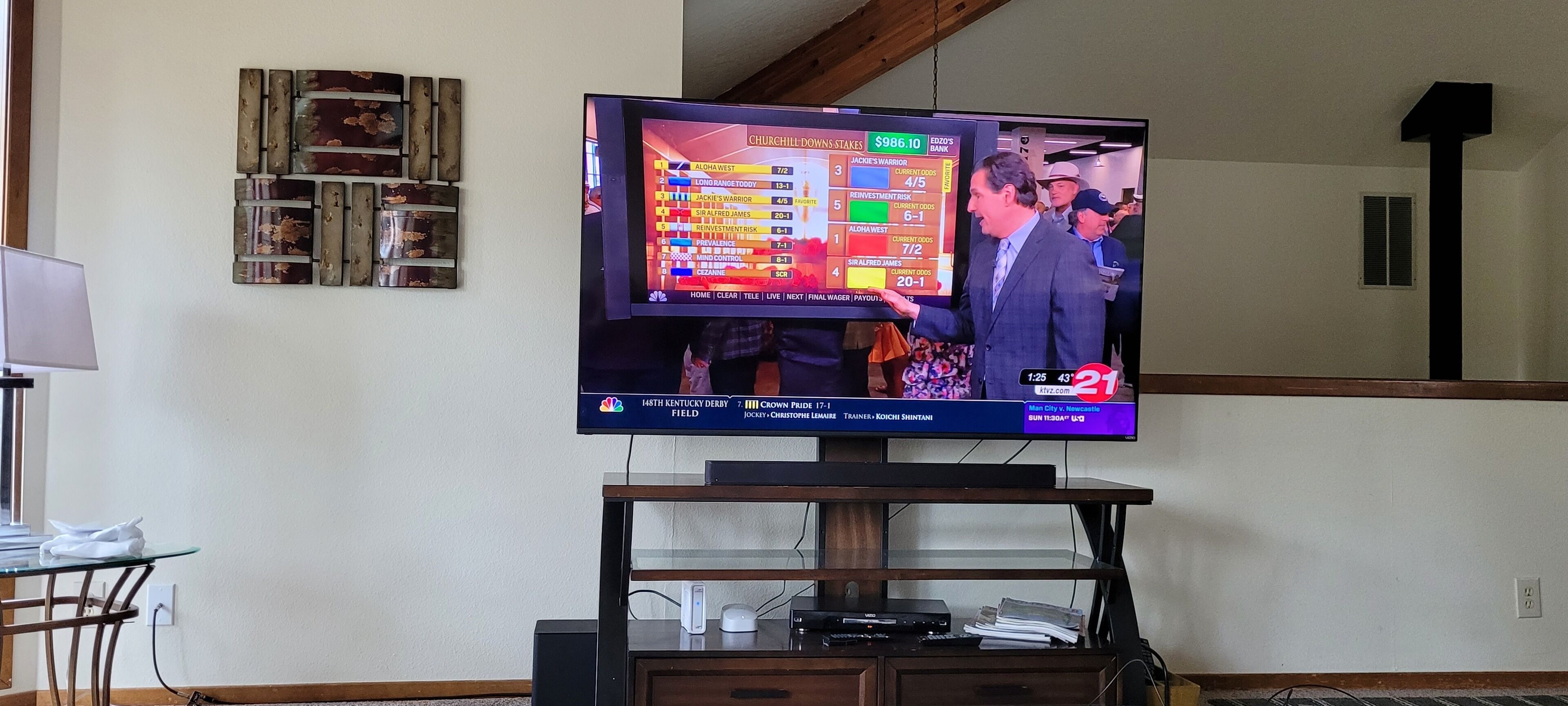 Ein an der Wand befestigter Fernseher zeigt eine Sportwetten-Oberfläche.