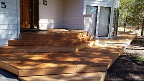 A wooden deck with steps leading to a house entrance. - 3500 Sq Ft Home 4 Suites Pool Table, Hot Tub, Bikes, EV Charger, 4th Night Free! (Bend)