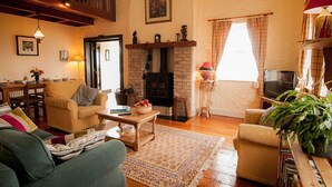 Un salon chaleureux avec une cheminée, des meubles en bois et un balcon.