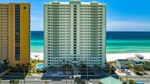 Un hôtel de grande hauteur doté de nombreux balcons, d’un espace piscine et offrant une vue sur la plage.