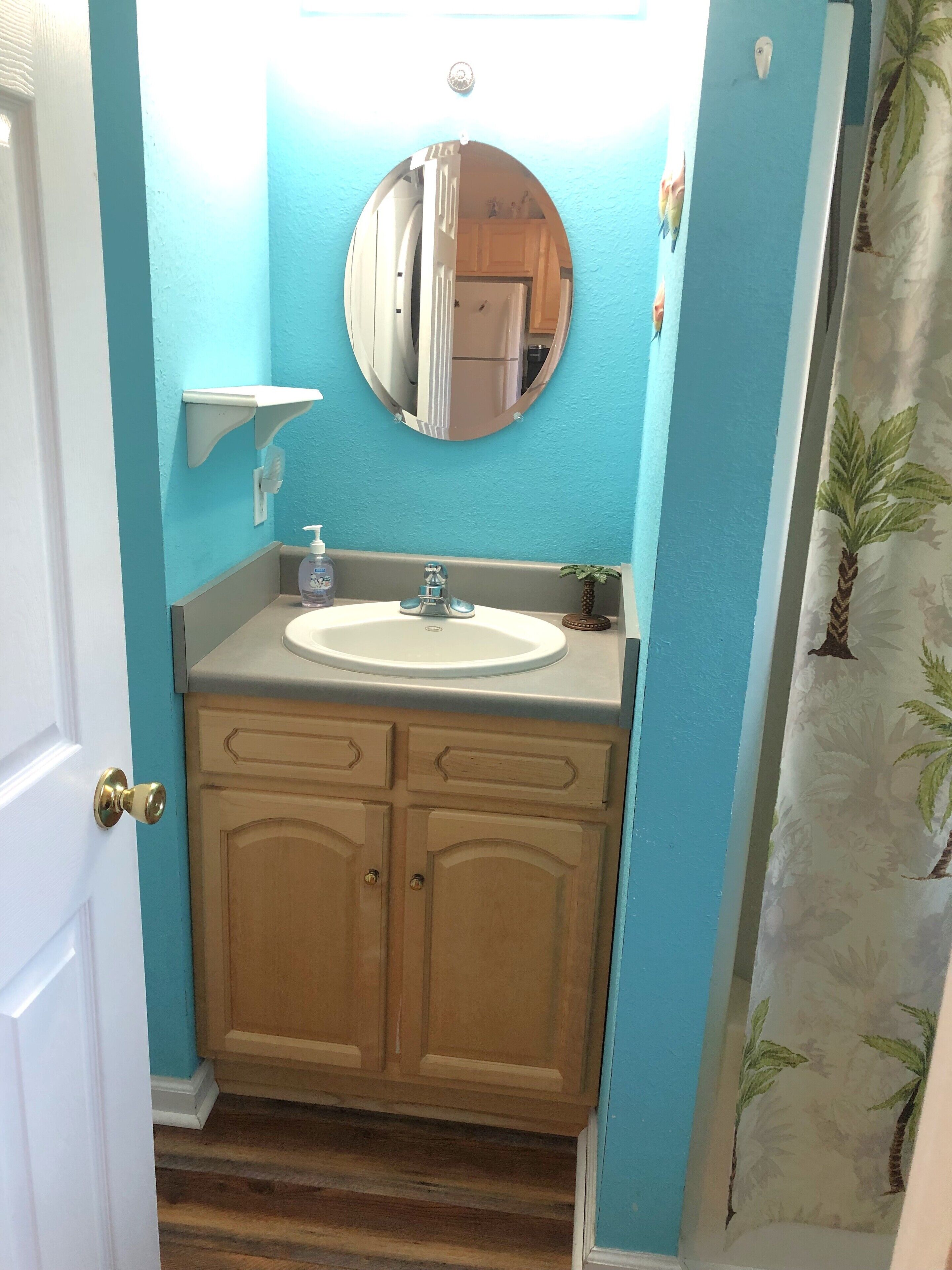 A bathroom with a sink, mirror, and wooden cabinets.