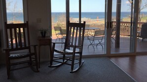 A room with a view of the ocean through large glass doors, a rocking chair, a small table, and a potted plant. - Direct access to the beach! (Plymouth)