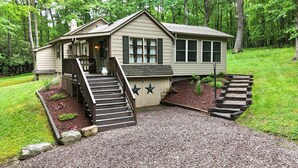 Ein eingeschossiges Haus mit Veranda, Treppe und kleinem Garten.