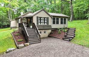 A single-story house with a porch, a staircase, and a small garden area.
