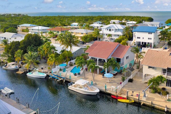A coastal residential area with houses, a marina, and a swimming pool.