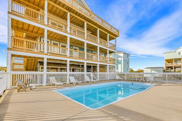 A multi-story building with a pool and outdoor seating.