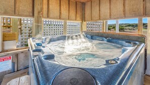 Banyera d'hidromassatge amb interior de fusta i vista a l'exterior.