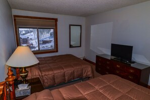 Slumber in the large master bedroom with 2 queen beds, dresser, closet and TV