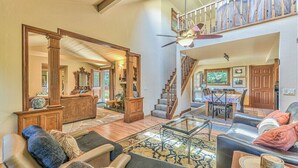 A spacious living room with a high ceiling, a staircase, and a dining area. - Carmel Valley Village, close to Big Sur, Pebble, Carmel, & Monterey (Carmel Valley)