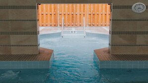 Une piscine entourée d’une clôture en bois et une horloge fixée au mur.