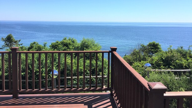 Una terraza de madera con vista al océano.