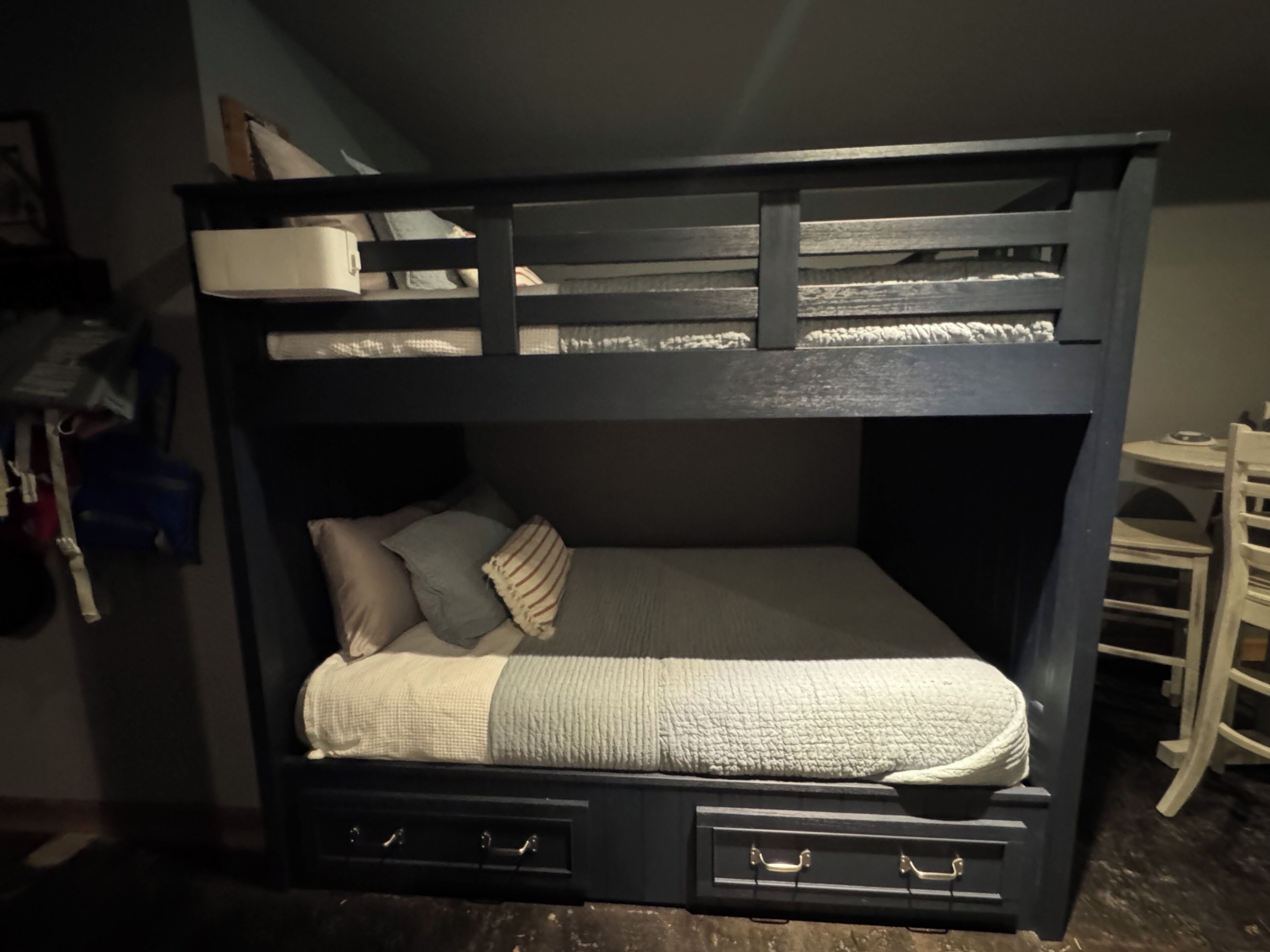 Una cama litera con cajones de almacenamiento y zona de escritorio.