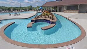 Une piscine au design incurvé, entourée de chaises longues et d’un espace de détente abrité.