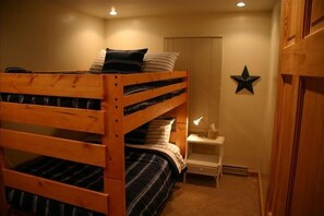 Habitación con literas, mesita de noche y decoración con estrellas en la pared.