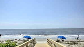 A wooden boardwalk leading to a beach with two blue umbrellas. - Beautiful Ocean Views, Beach Club 337! Steps to beach! (St. Simons Island)