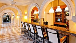 Un'area bar con soffitti alti ad arco e pavimento a scacchi.