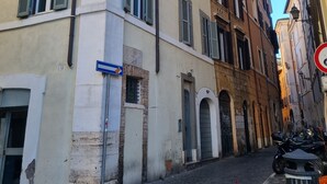 Una estrecha calle adoquinada flanqueada por edificios históricos, con un letrero que dice "Nicolo del Giglio" y una señal azul direccional.