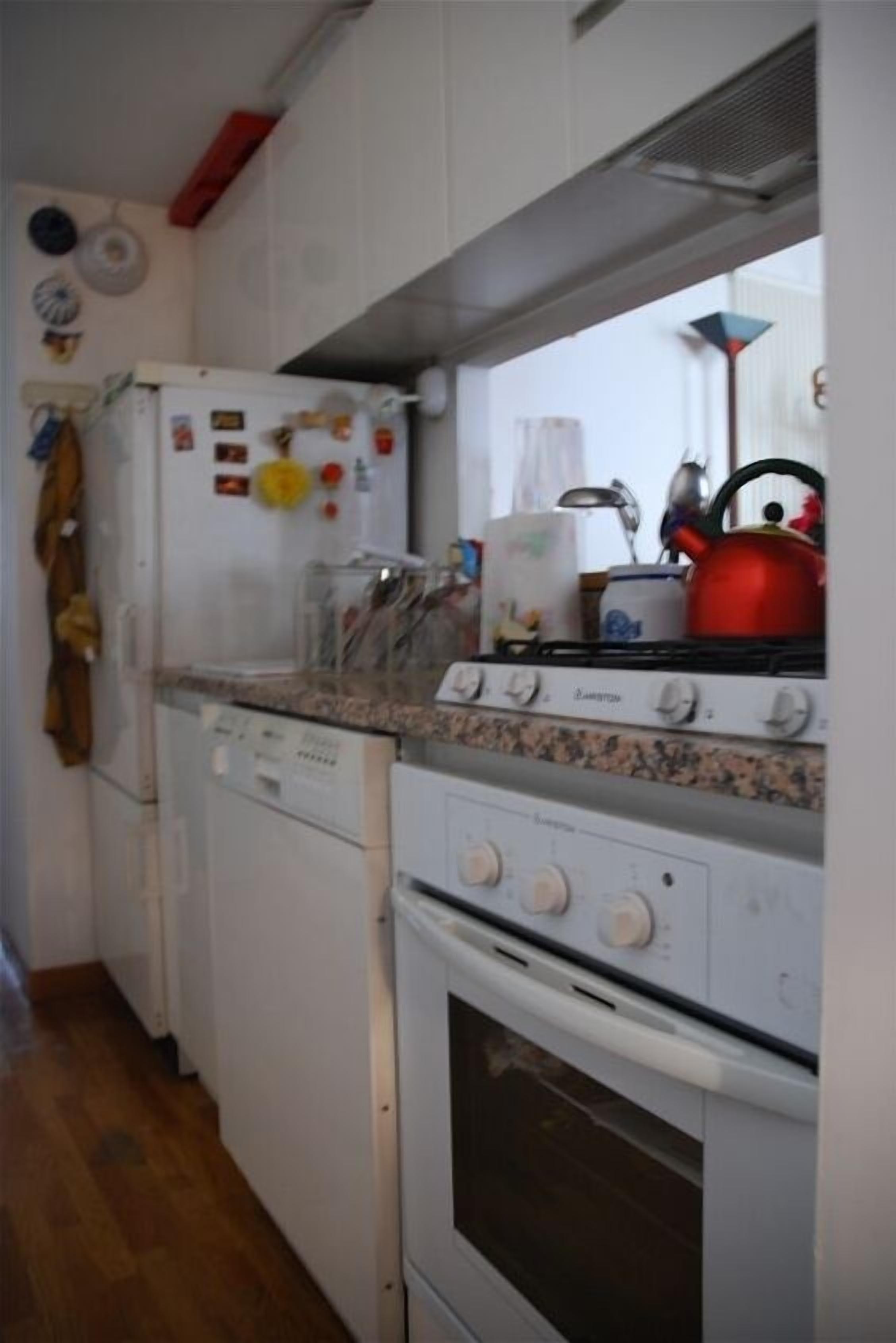 A compact kitchen with white appliances, a gas stove, and a dishwasher.