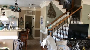 A spacious living area with a staircase, a dining table, and a cozy seating area. - Gorgeous 5 bdrm OCEAN LAKES FAMILY CAMPGROUND MH137C (Myrtle Beach)